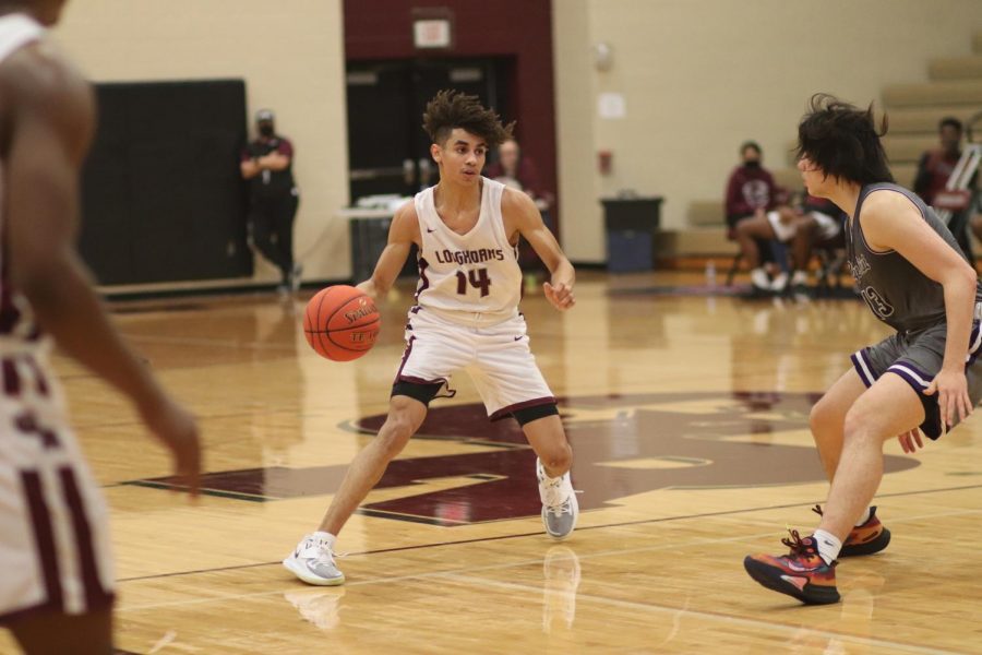 No. 14 Jullian Camper (12) using his dribbling skills to navigate around his opponents.