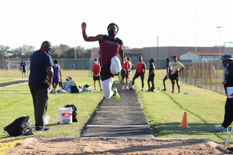 Ademola Bello (11) was soaring through the air trying to beat his PR for the long jump.