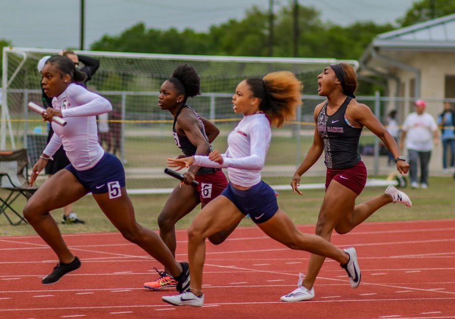 Gabby+Ayiteyfio+%2812%29+screams+on+for+her+teammate+and+last+leg+of+the+girls+4x100+meter+race%2C+Journie+Franklin+%289%29.+The+Longhorns+placed+third+in+the+race+advancing+them+to+the+Regional+meet.