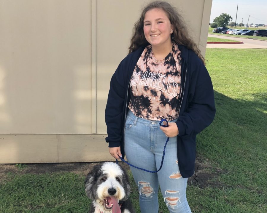 Kassandra Kee stands with Scout one of the classroom dogs in her Animal Science Class.