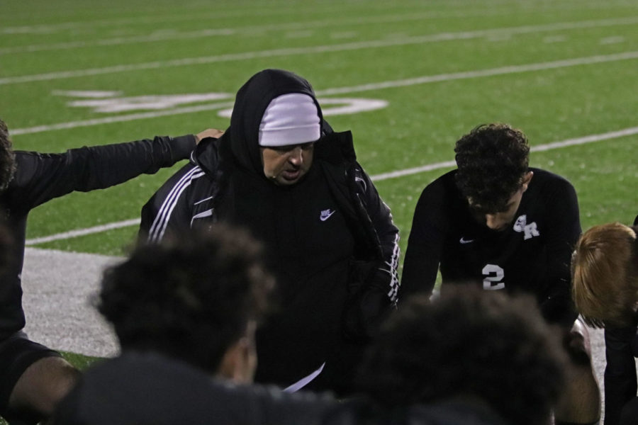 Coach Hansen leads his team in a prayer before the start of the game.