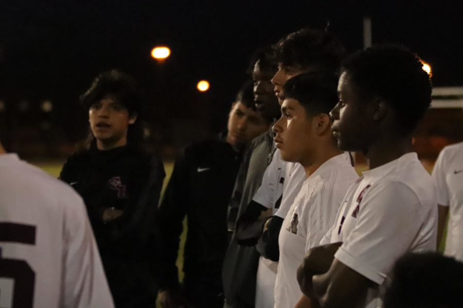 The JV team listening to advice and instructions from the coach during halftime.