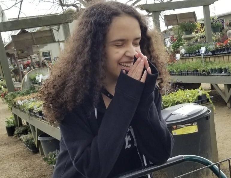 Kaila poses with laughter outside a store.