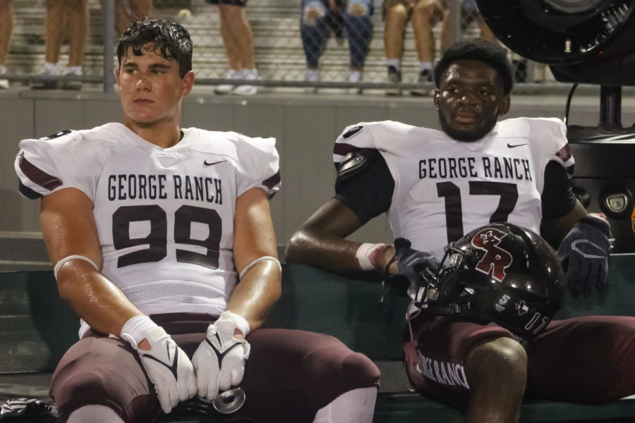 Cody Ford (11) and Henry Chuckwu (12) sitting on the sidelines after a tough game.